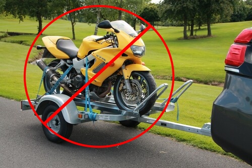 Foto de moto honda VTR 100 amarilla en un trailer con un signo de prohibido sobre ella
